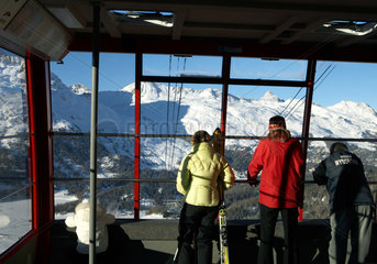 Passagiere einer Bergbahngondel geniessen den Panoramablick