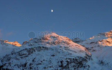 Verschneite Berggipfel in der Abenddaemmerung im Oberengadin