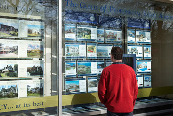 London - Mann studiert Immobilienangebote im Schaufenster