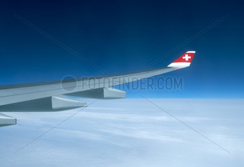 Blick aus einem Flugzeig der Fluggesellschaft Swiss hoch ueber den Wolken