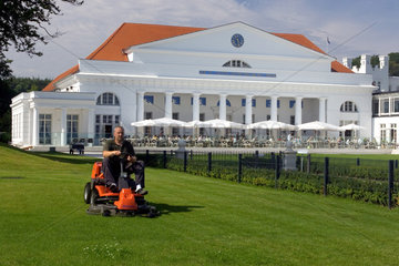 Heiligendamm  Gaertner maeht den Rasen vor der Kurhalle des Grand Hotel Kempinski