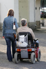 Dresden  eine Frau begleitet einen Rentner im Rollstuhl