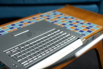Ein aufgeklapptes Notebook auf einem Beistelltisch