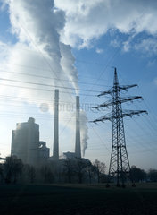 Kohlekraftwerk mit Rauch- und Dampfwolken im Gegenlicht