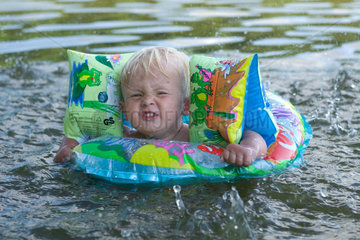 Badespass  ein kleines Kind planscht im Wasser