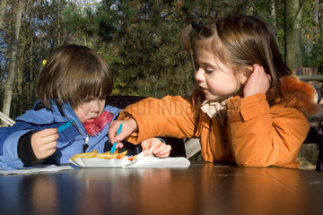 Zwei Kinder essen Pommes frites