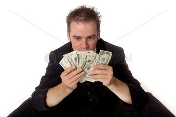 Ein Geschaeftsmann haelt Dollarscheine in der Hand