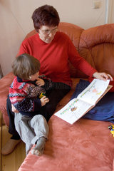 Eine Frau liest einem Kind etwas vor