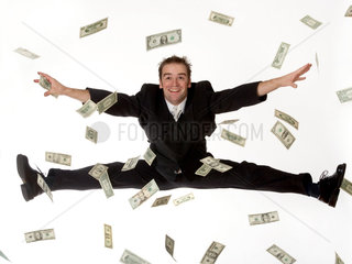 Ein Mann springt durch flatternde Banknoten