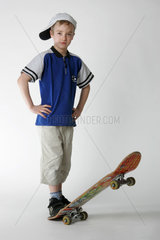 Junge posiert kess mit seinem Skateboard