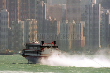 Ein Schnellboot faehrt auf dem Wasser vor Hong Kong