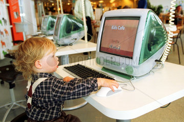 Ein kleiner Junge sitzt vor einem Computer