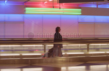 Eine Frau in einem Gang des Muenchener Flughafen