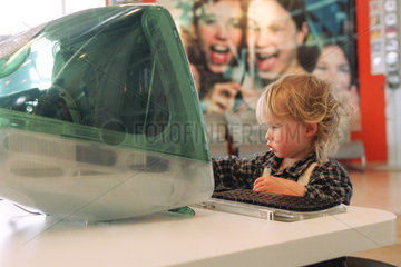 Ein kleiner Junge sitzt vor einem Computer