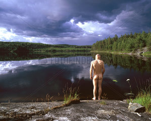 Gewitterstimmung an einem See in Schweden und nackter Mann