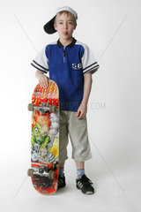 Junge posiert kess mit seinem Skateboard