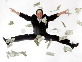 Ein Mann springt durch flatternde Banknoten