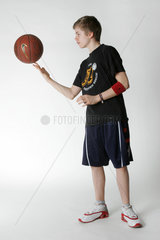 Ein Junge jongliert mit einem Basketball