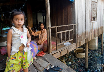 Phnom Penh  Kambodscha  ein Maedchen steht neben ihrem Elternhaus