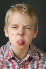 Emotion  ein Junge steckt die Zunge heraus