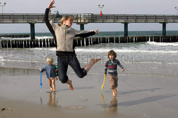 Graal Mueritz  eine Mutter vergnuegt mit ihren Kindern am Strand