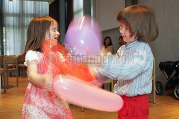 Zwei Kinder spielen mit Luftballons