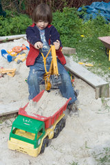Ein Kind spielt im Sandkasten