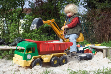 Ein Kleinkind spielt im Sandkasten