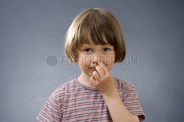 Ein Kind mit dem Finger in der Nase