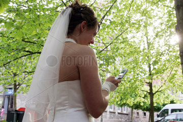 Eine Braut telefoniert mit ihrem Handy