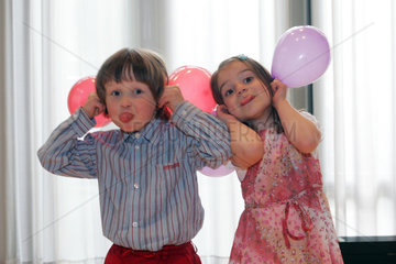 Zwei Kinder spielen mit Luftballons