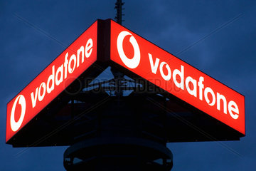 Berlin  beleuchtetes Logo von Vodafone auf einem Sendemast bei Nacht