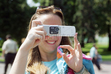 Moskau  junge Frau macht ein Foto mit Ihrer Handy Kamera