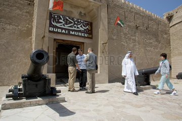 Dubai  ein Araber und mehrere Touristen vor dem Eingang des Dubai-Museum