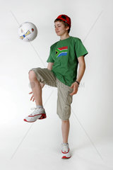 Junge beim Kicken mit einem Fussball