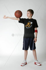 Ein Junge jongliert mit einem Basketball