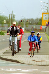 Eltern mit ihren Kindern beim Fahrrad fahren auf der Strasse