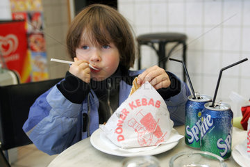 Berlin  ein Kind isst einen Doener Kebap