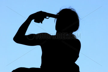 Symbolfoto  ein Mensch haelt sich eine Pistole an die Schlaefe