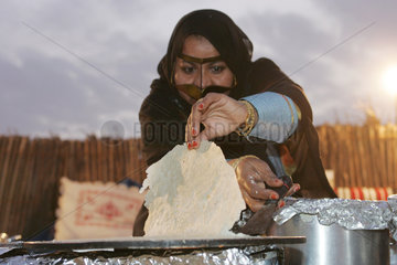 Dubai  eine verschleierte Frau beim traditionellen Kochen