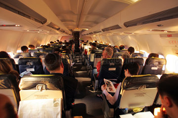 Muenchen  Passagiere in einer Flugzeugkabine