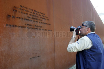 Berlin  ein Tourist fotografiert die Gedenktafel im Mauerpark an der Bernauer Strasse