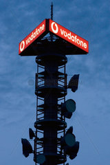 Berlin  ein Vodafone Sendemast mit Richtfunkgeraeten bei Nacht