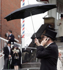 York  Mann mit Schirm telefoniert