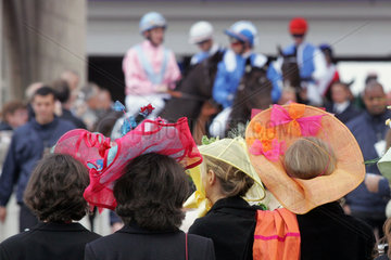 Paris  Frauen mit Hueten beobachten die Pferde und Reiter auf der Rennbahn Longchamp