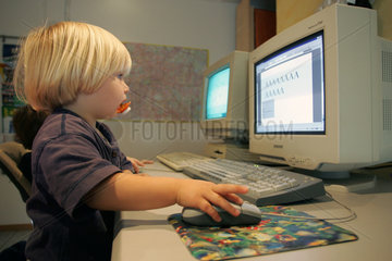 Berlin  ein Kleinkind sitzt vor einem Computer