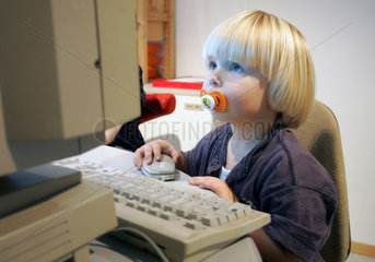 Berlin  ein Kleinkind sitzt vor einem Computer