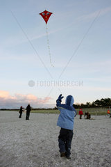 Zingst  ein Kind laesst am Strand seinen Drachen steigen