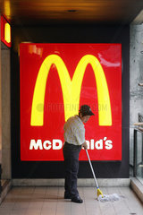 Hong Kong  Reinigungskraft wischt vor einem Logo von McDonalds