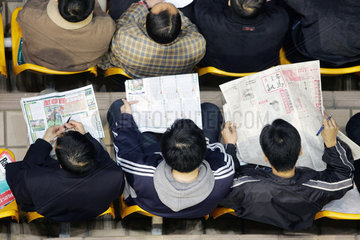 Hong Kong  Menschen sitzen auf einer Tribuene